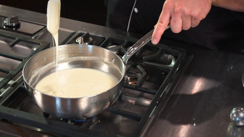 Chef Preparing a Creamy Fontina Cheese Sauce